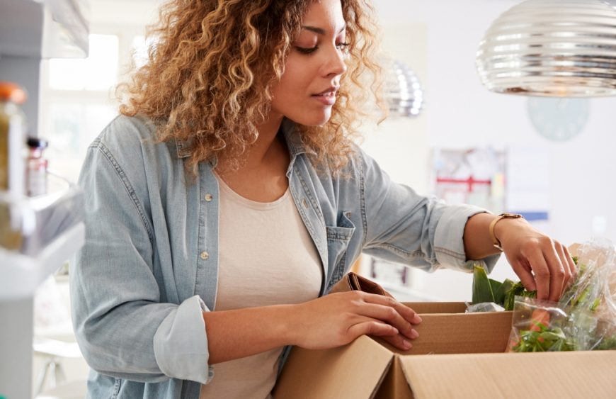 woman-stocking-fridge-with-food